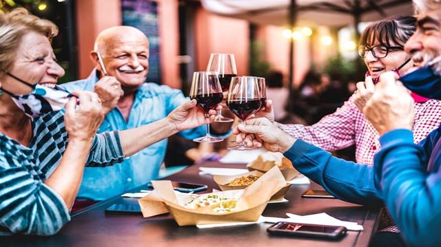 elderly group toast with glass of wine